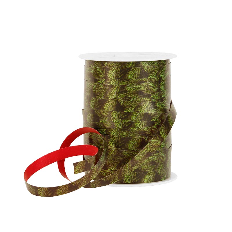 Curling gift ribbon one side printed with Christmas tree branch motifs, other side plain red
